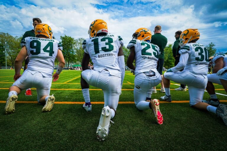 american footballers crouching on field
